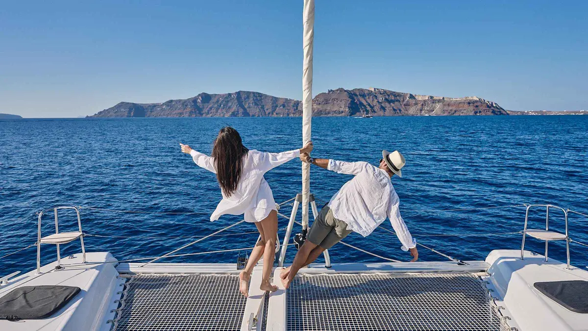 Classic catamaran moored near Red Beach on a Santorini catamaran cruise with BBQ and drinks