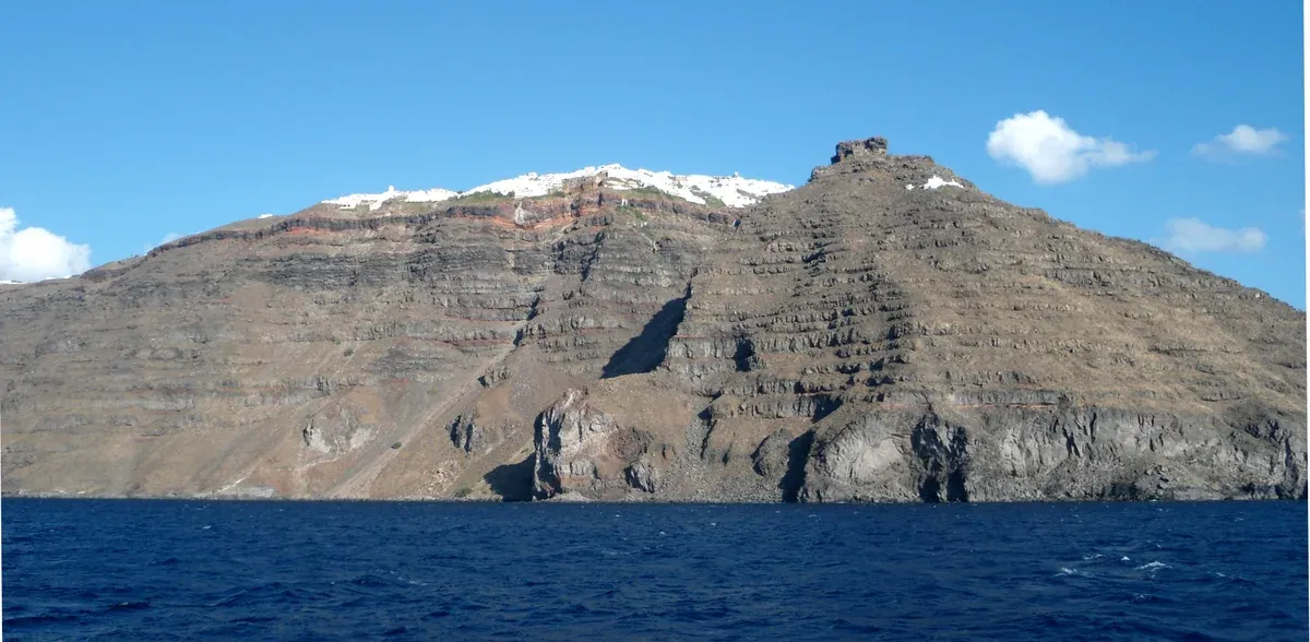 Skaros rock and the Imerovigli cliffs rising from the caldera on a Santorini catamaran cruise
